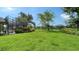 Lush green backyard with view of screened pool and beautiful lake beyond at 7426 Weeping Willow Blvd, Sarasota, FL 34241