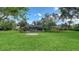 Vast green backyard with a screened pool area and lush landscaping for privacy and outdoor enjoyment at 7426 Weeping Willow Blvd, Sarasota, FL 34241