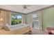 Bright bedroom features a ceiling fan, carpeted floors, and a large window offering natural light at 7426 Weeping Willow Blvd, Sarasota, FL 34241