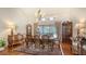 Traditional dining room featuring a chandelier, hardwood floors, and large windows with backyard views at 7426 Weeping Willow Blvd, Sarasota, FL 34241