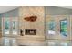 Close-up of a stone fireplace with glass doors and views of the outdoor patio at 7426 Weeping Willow Blvd, Sarasota, FL 34241