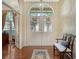 Inviting foyer with double doors, decorative wreaths, hardwood floors, elegant bench, and view into adjacent living spaces at 7426 Weeping Willow Blvd, Sarasota, FL 34241