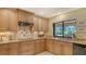 This kitchen boasts granite counters, tile backsplash, wood cabinets and stainless steel appliances with a garden view at 7426 Weeping Willow Blvd, Sarasota, FL 34241