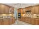 Kitchen featuring wood cabinetry, stainless steel appliances, granite countertops, and easy access to the dining area at 7426 Weeping Willow Blvd, Sarasota, FL 34241