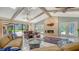 Comfortable living room with vaulted ceilings, stone fireplace, and access to outdoor entertaining area at 7426 Weeping Willow Blvd, Sarasota, FL 34241