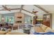 Cozy living room featuring a stone fireplace, wood beamed ceiling, and views of the outdoor patio at 7426 Weeping Willow Blvd, Sarasota, FL 34241