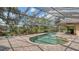 Screened-in pool features brick pavers and lush landscaping, offering a private outdoor retreat with serene views at 7426 Weeping Willow Blvd, Sarasota, FL 34241