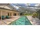 A spacious screened-in pool is surrounded by brick pavers and lounging furniture for ultimate relaxation and enjoyment at 7426 Weeping Willow Blvd, Sarasota, FL 34241