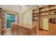 Organized walk-in closet with custom wood shelving and island dresser at 7426 Weeping Willow Blvd, Sarasota, FL 34241