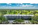 Aerial view of building near golf course with lush green fairways and blue skies at 7461 W Country Club N Dr # 206, Sarasota, FL 34243