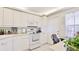 Well-lit kitchen boasting white cabinets, appliances, and a window with natural light at 7461 W Country Club N Dr # 206, Sarasota, FL 34243