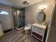 Neutral bathroom featuring a glass shower, wood-look tile flooring, and modern vanity with updated fixtures at 7511 1St W Ave, Bradenton, FL 34209