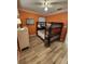 Bright bedroom with a bunk bed, wood-look floors, an orange accent wall, and a ceiling fan at 7511 1St W Ave, Bradenton, FL 34209