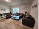 Inviting living room with dark sofas, a coffee table, light hardwood flooring, and bright natural lighting at 7511 1St W Ave, Bradenton, FL 34209