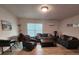Comfortable living room with dark sofas, wood flooring, a coffee table, and bright natural lighting at 7511 1St W Ave, Bradenton, FL 34209