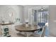 Bright dining area features a round wooden table, white chairs, decorative mirror, and sliding glass doors at 7915 115Th E Ave, Parrish, FL 34219