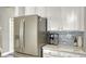 Kitchen detail showcases the stainless refrigerator, white cabinets, and a coffee maker on the countertop at 7915 115Th E Ave, Parrish, FL 34219