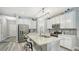 The kitchen features white cabinets, stainless appliances, an island with barstool seating and stylish decor at 7915 115Th E Ave, Parrish, FL 34219