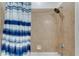 Shower area featuring tiled walls, a shower head, and a stylish blue-and-white shower curtain at 7915 115Th E Ave, Parrish, FL 34219