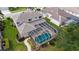 Aerial view of the property with a screened-in pool and spa, surrounded by lush landscaping at 7915 Kavanagh Ct, Sarasota, FL 34240