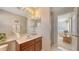 A bright bathroom showcasing a spacious vanity, decorative mirrors, and walk-in shower adjacent to a serene bedroom view at 7915 Kavanagh Ct, Sarasota, FL 34240