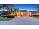 Well-lit home exterior showing the front yard, driveway and three car garage at 7915 Kavanagh Ct, Sarasota, FL 34240