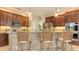 Kitchen featuring wood cabinets, granite countertops, tile backsplash, and bar seating at 7915 Kavanagh Ct, Sarasota, FL 34240