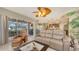 Open living room with a ceiling fan and access to an outdoor patio and kitchen at 7915 Kavanagh Ct, Sarasota, FL 34240