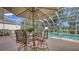 A screened-in patio with a dining set and a view of the pool, perfect for entertaining and relaxing at 7915 Kavanagh Ct, Sarasota, FL 34240