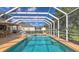A screened-in pool boasts clear blue water and ample space for seating and recreation at 7915 Kavanagh Ct, Sarasota, FL 34240