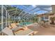 Bask in the sun on this screened-in patio with a pool, hot tub, lounge chairs, and outdoor dining area at 7915 Kavanagh Ct, Sarasota, FL 34240
