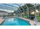 The screened pool has a spa, volleyball net, mature trees, and open views of the surrounding landscape at 7915 Kavanagh Ct, Sarasota, FL 34240