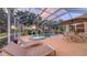 Screened patio with a pool, hot tub, lounge chairs, and a dining set, perfect for enjoying outdoor living at 7915 Kavanagh Ct, Sarasota, FL 34240