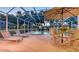 Experience luxury with a screened-in pool, hot tub, lounge chairs, and a dining set on the spacious patio at 7915 Kavanagh Ct, Sarasota, FL 34240