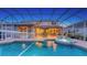 A screened pool and spa setup with volleyball net offer a relaxing and fun backyard experience at 7915 Kavanagh Ct, Sarasota, FL 34240
