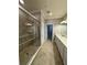 Long bathroom features tiled floors, walk in shower, and a closet at 10054 Crooked Creek Dr # 201, Venice, FL 34293