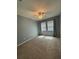 Spacious bedroom with plush carpet, neutral walls, ceiling fan, and natural light from large windows at 10054 Crooked Creek Dr # 201, Venice, FL 34293