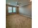 Cozy carpeted bedroom features large windows and neutral decor at 10054 Crooked Creek Dr # 201, Venice, FL 34293