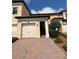 Two story home showcasing the front exterior with a red brick driveway and an attached two car garage at 10054 Crooked Creek Dr # 201, Venice, FL 34293