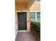Inviting front door entrance framed by lush greenery and brick pathway, adjacent to a window at 10054 Crooked Creek Dr # 201, Venice, FL 34293