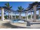 Relaxing hot tub surrounded by pergola, columns, and lounge chairs at 10054 Crooked Creek Dr # 201, Venice, FL 34293