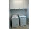Laundry room features modern washer and dryer and overhead cabinets at 10054 Crooked Creek Dr # 201, Venice, FL 34293
