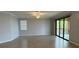 Neutral living area with tile floors, large window, and sliding door to balcony at 10054 Crooked Creek Dr # 201, Venice, FL 34293