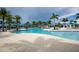 Gorgeous community pool area surrounded by palm trees and lounge chairs at 10054 Crooked Creek Dr # 201, Venice, FL 34293