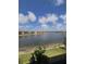 Beautiful view of lake surrounded by residential buildings with blue sky and scattered clouds at 10054 Crooked Creek Dr # 201, Venice, FL 34293