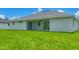 Manicured backyard, showcasing the home's neutral color palette and covered patio at 10443 Riverside Rd, Port Charlotte, FL 33981