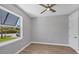 Bedroom with light gray walls, wood floors, ceiling fan and double-paned window at 10443 Riverside Rd, Port Charlotte, FL 33981