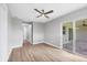 Bedroom featuring wood floors, a ceiling fan, a sliding glass door, and a closet at 10443 Riverside Rd, Port Charlotte, FL 33981