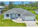 An elevated view of a single Gathering home displaying an attached two car garage and manicured landscaping at 10443 Riverside Rd, Port Charlotte, FL 33981