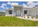 Inviting home entrance with decorative stone landscaping, colorful foliage and grey toned exterior at 10443 Riverside Rd, Port Charlotte, FL 33981